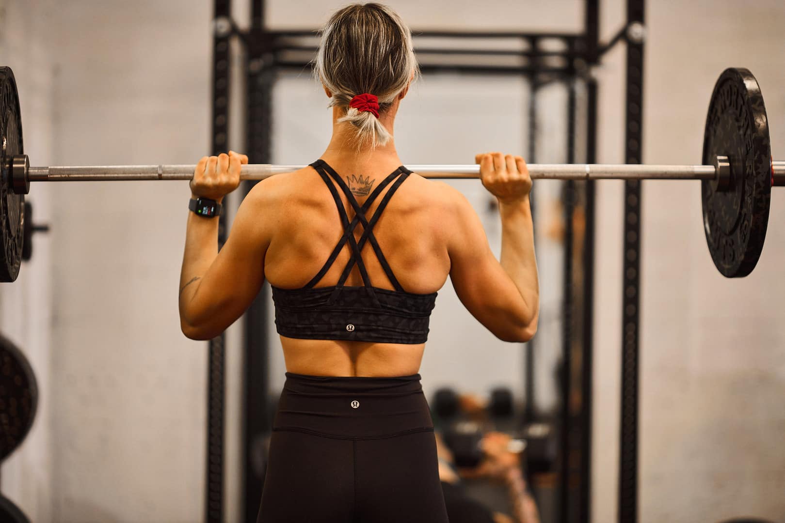 A girl pushing a barbell overhead in victoria, bc