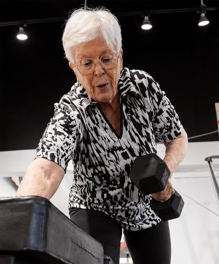 senior personal training client rowing dumbbell