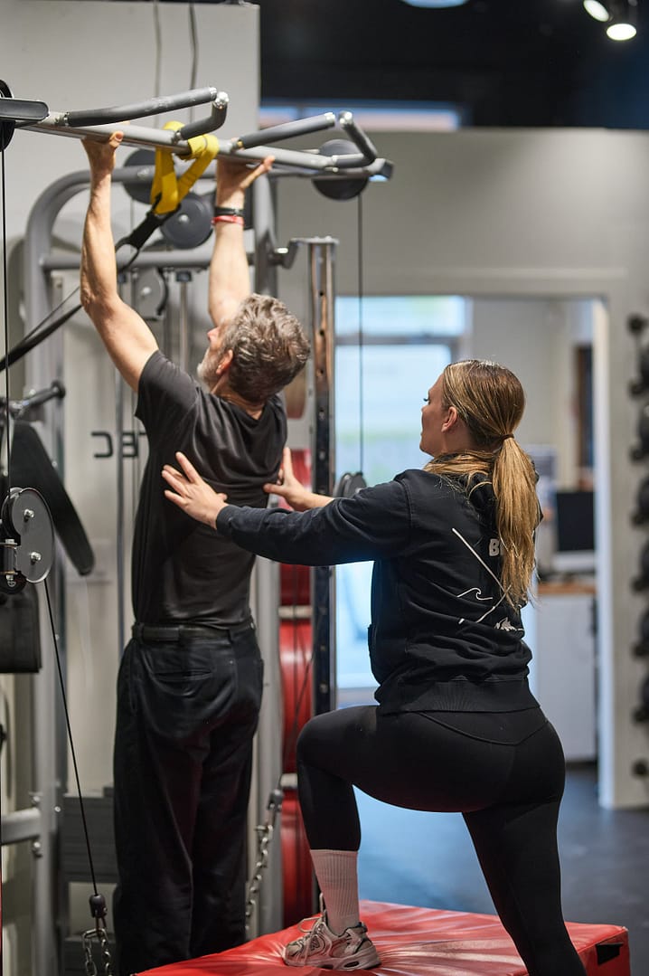 senior personal training client doing chin ups