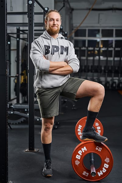 Dedicated fitness coach spotting a client during a bench press at BPM Fitness Centre.